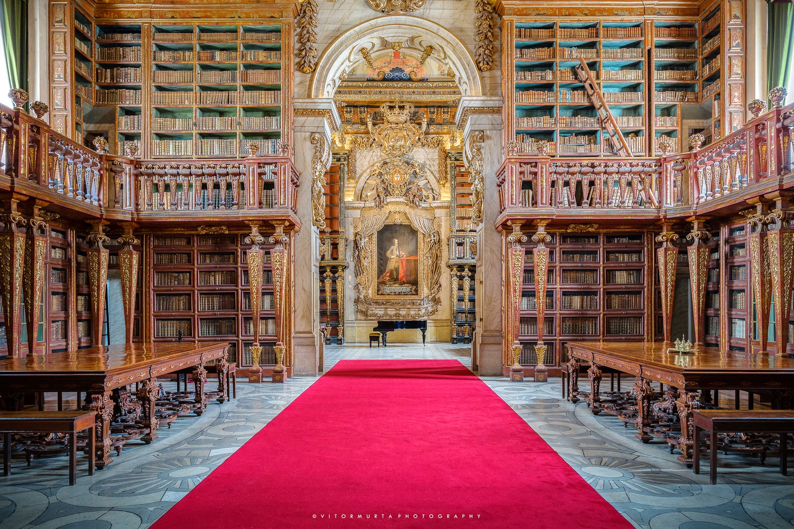 Interior da Biblioteca Joanina, com piano de cauda e pintura ao fundo, Universidade de Coimbra. Imagem ilustrativa texto bibliotecas mais bonitas do mundo.