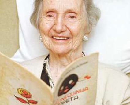 Autora Alaíde Lisboa de Oliveira com o livro A Bonequinha Preta original.