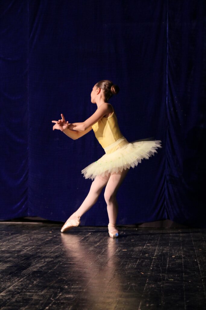 Menina com roupa marela de bailarina. Imagem ilustrativa texto inciar as crianças na dança.