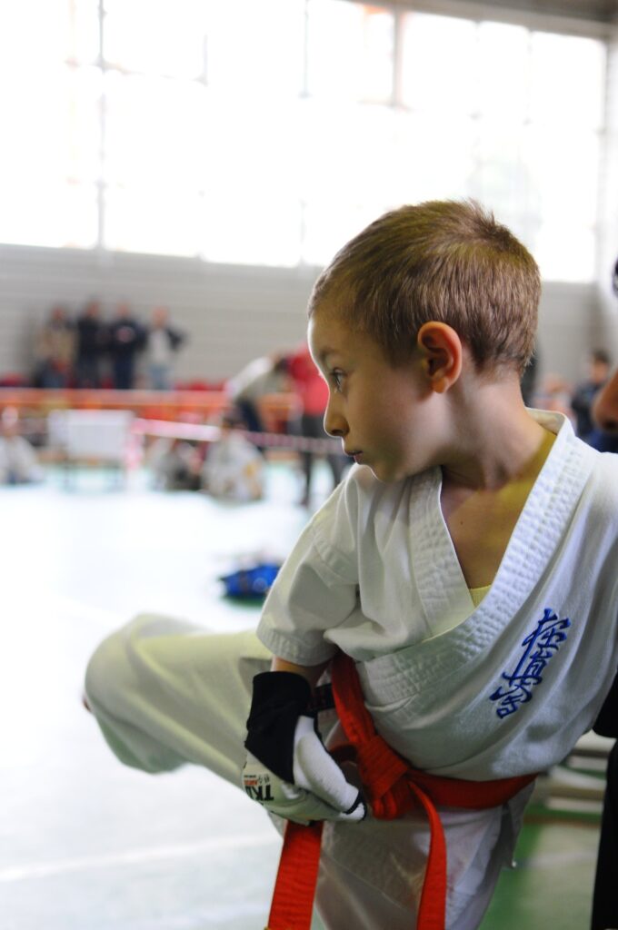 Menino de quimono, praticando artes marciais. Imagem ilustrativa texto iniciar as crianças nos esportes.