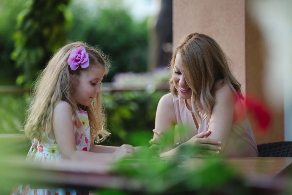 Mãe e filha conversando ao ar livre. Imagem ilustrativa texto saúde mental infantil.