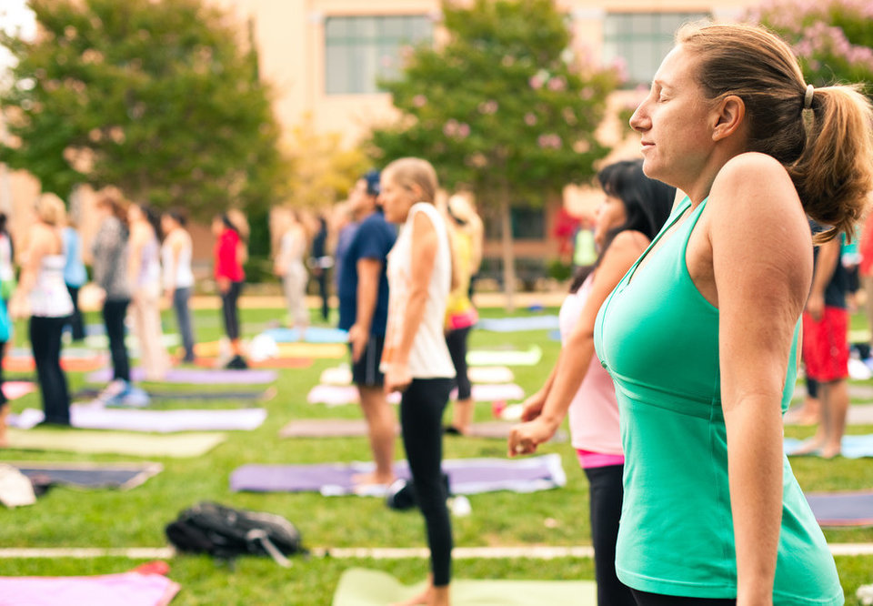 Mulheres praticando ioga ao ar livre. Imagem ilustrativa texto saúde mental de professores.