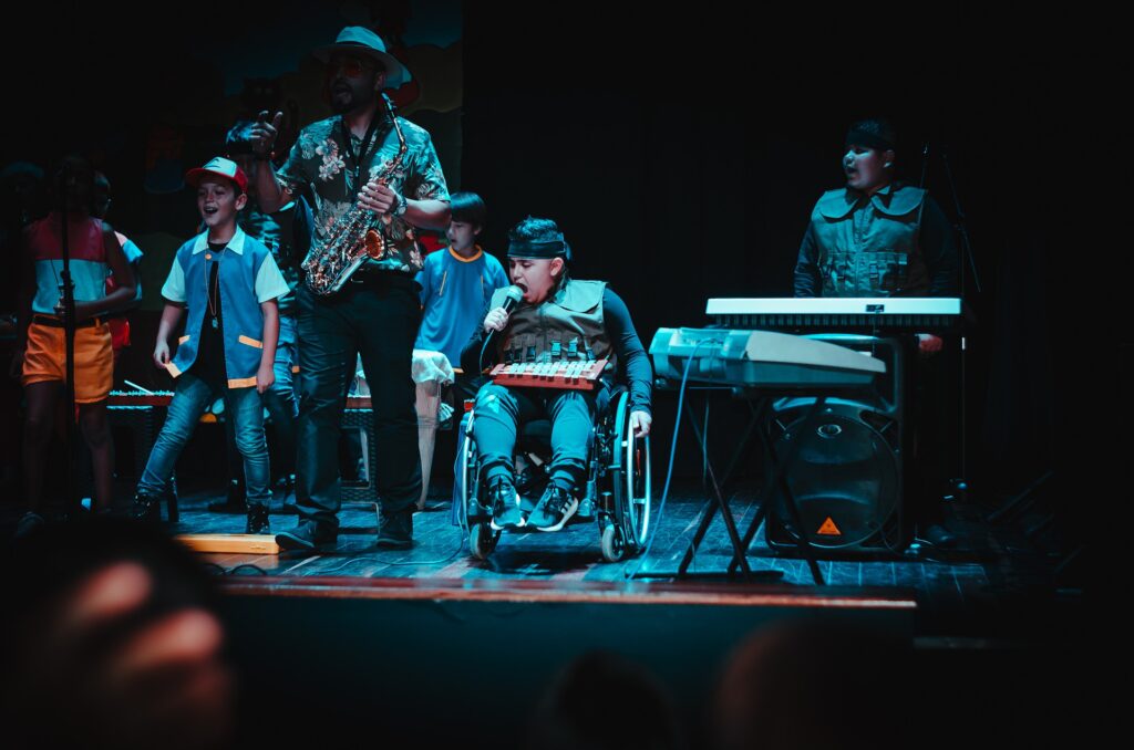 Show de talentos na escola, com banda e pessoa cadeirante.. Imagem ilustrativa texto evasão escolar.