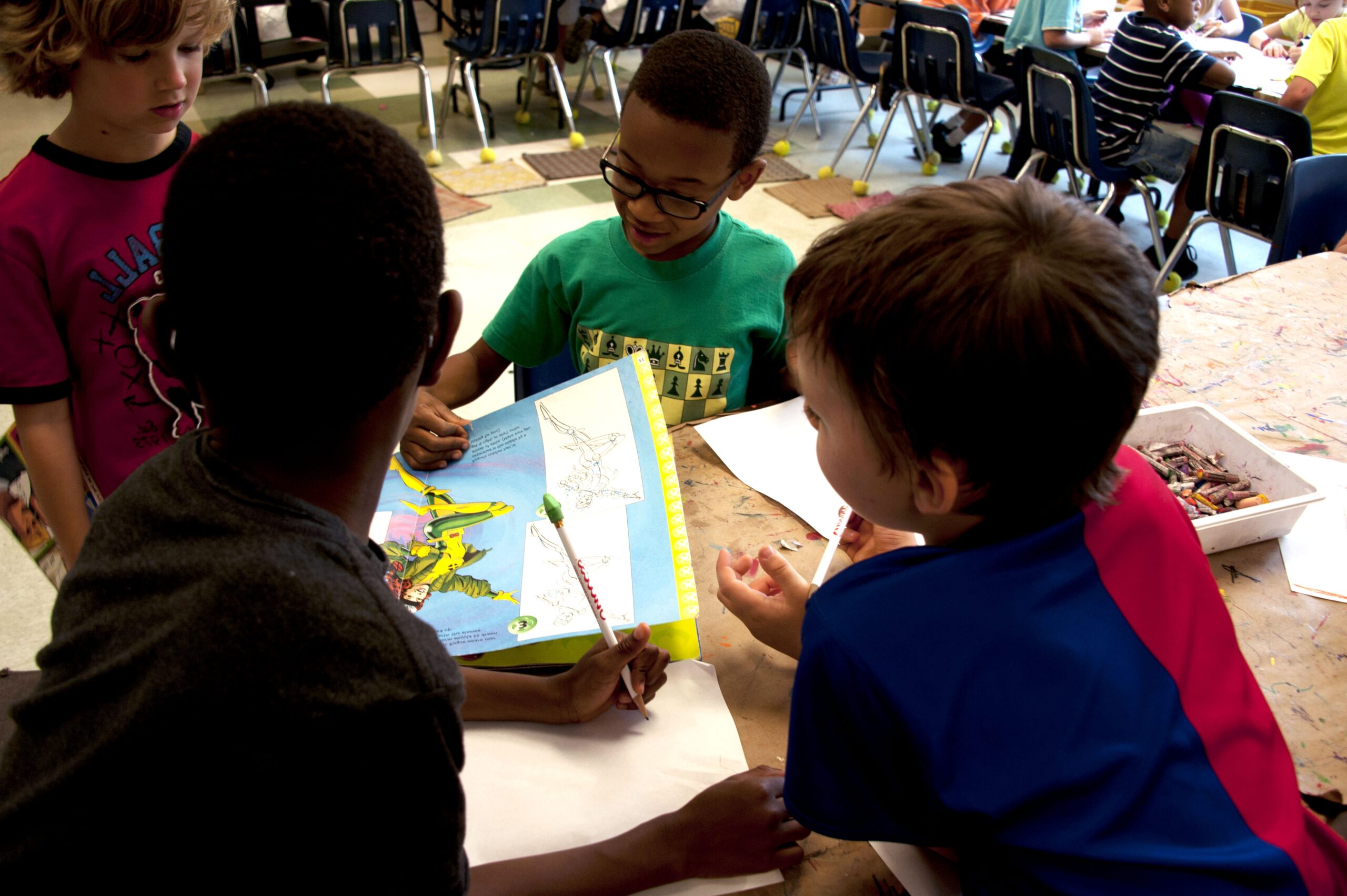 Meninos na escola com livro e giz de cera. Imagem ilustrativa texto projeto literário.