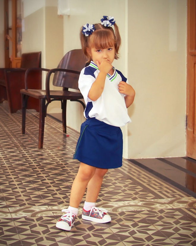 Menina usando uniforme escolar. Imagem ilustrativa texto materiais escolares.