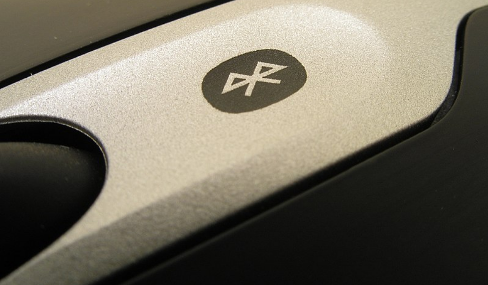 Detalhe de mouse com logo de Bluetooth. Imagem ilustrativa texto linguagens do dia a dia.