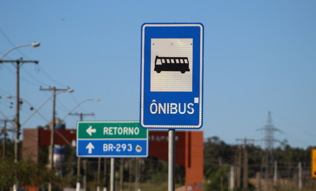 Placas de trânsito ônibus, retorno e BR-293. Imagem ilustrativa texto linguagens do dia a dia.