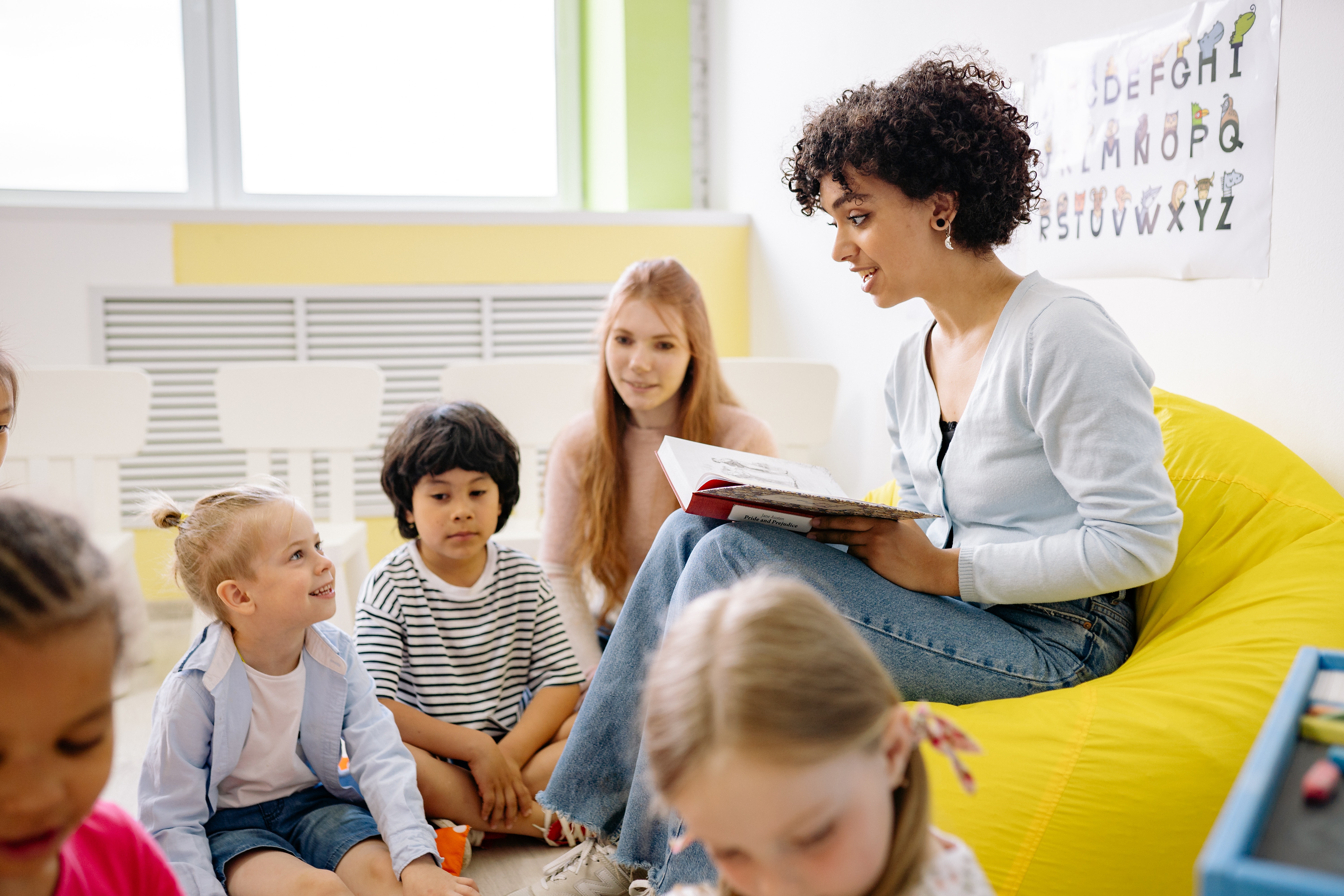 Mulher lendo para crianças. Imagem ilustrativa texto como escolher livros para escola.